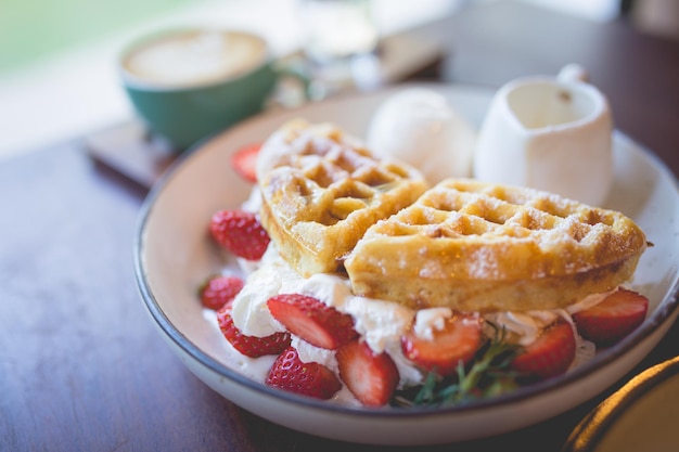 Foto wafel pannenkoek dessert met vanille-ijs verse aardbeien en honingsiroop