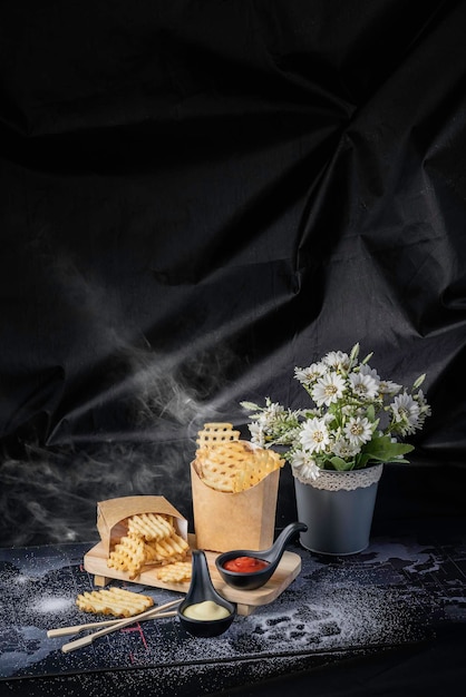 Wafelfrietjes, goudgele chips, rokerig, zwarte achtergrond