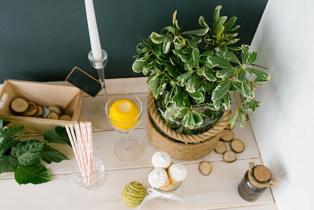 Wafelkegel met wit ijs in een glazen vaas, papieren buizen en een plant in een vaas op de keukentafel of in een café, bovenaanzicht