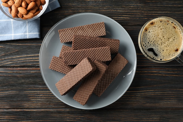 Wafels, kopje koffie en amandel op houten achtergrond, bovenaanzicht