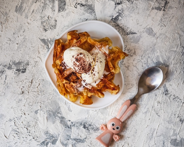 Wafels met ijs en chocoladeschilfers op een bovenaanzicht van een witte schotel