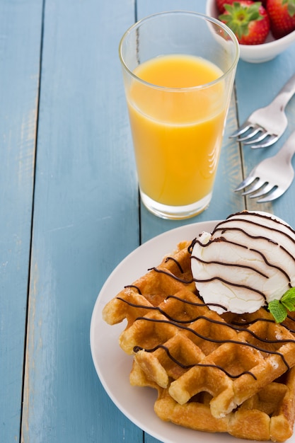 Wafels met ijs op blauwe houten tafel