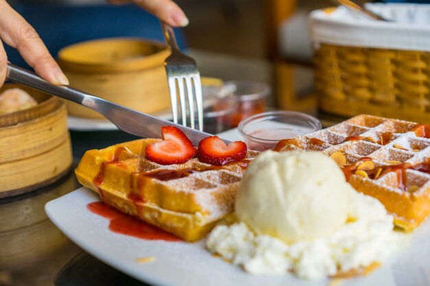 Wafels met verse rijpe rode aardbeien en ijs geserveerd op een bord