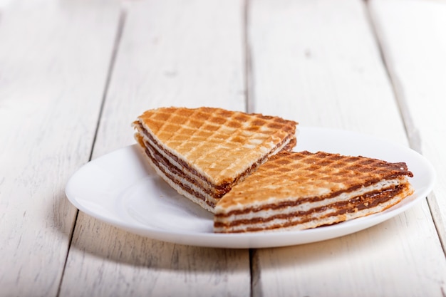 Wafelsandwiches met gekookte condens in plaat op witte houten lijst