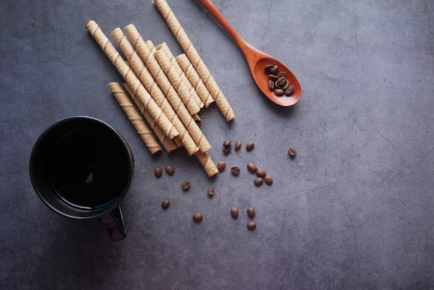 Wafer roll chocolade koffiebonen en koffie op zwart