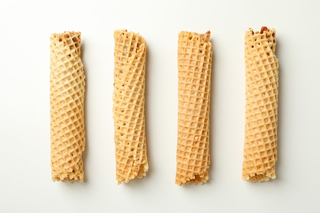 Wafer rolls with condensed milk on white background