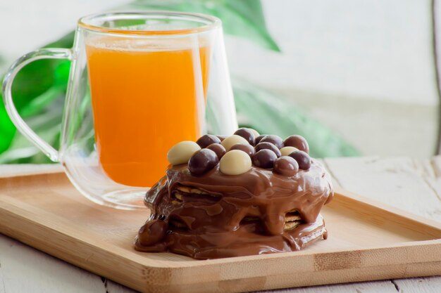 Wafers covered with chocolate cream and chocolate balls and a natural orange juice
