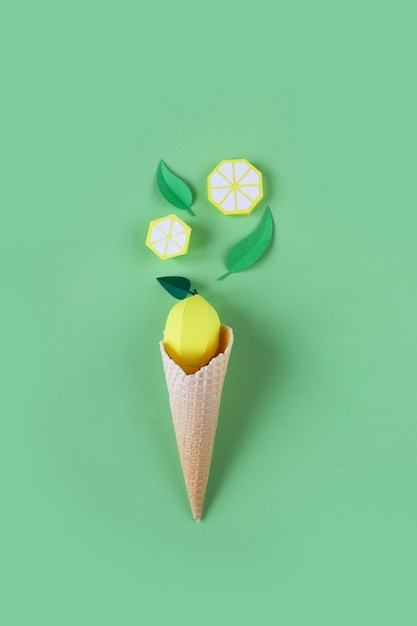 Waffle cone with paper fruits on green surface