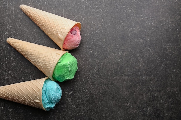 Waffle cones with colorful ice cream on table