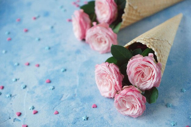 Waffle horns with flowers on blue background, Tenderness, St. Valentine's Day, Copy space, Selective focus