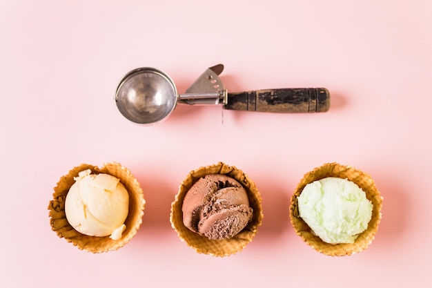 Waffle ice cream bowls with scoops of ice cream on a pink background.