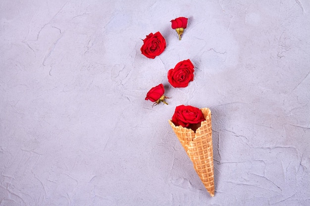 Waffle ice cream cone with rose flowers top view flat lay