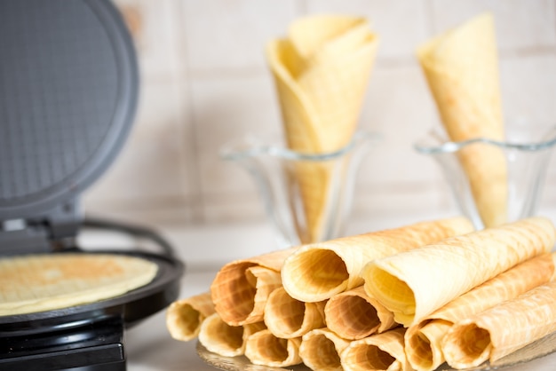 Waffle iron in the kitchen. Preparing homemade waffles, pouring a dough