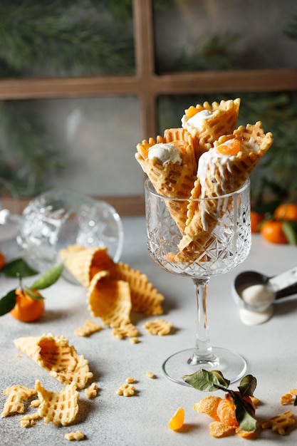 waffle tubes in a glass on the table with green leaves with ice cream