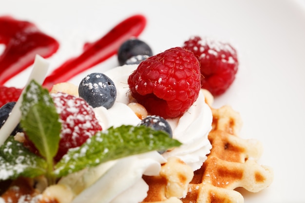 Waffles and cream with blueberries and raspberries