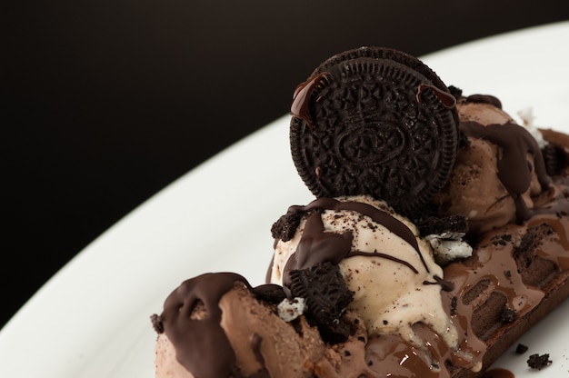 Photo waffles and ice cream in a dish on a dark background