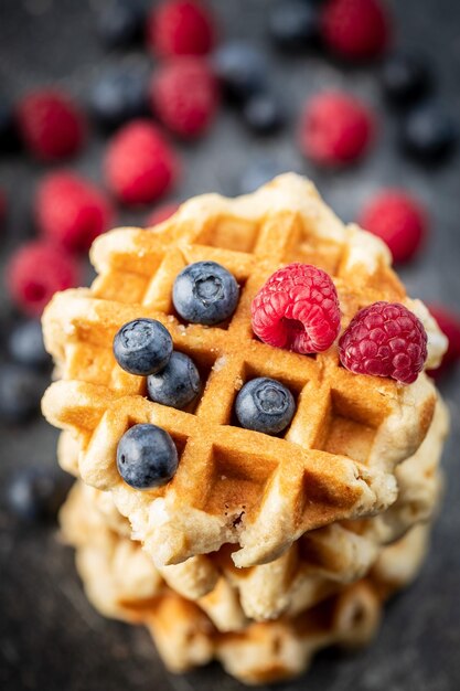 Waffles with blueberries and raspberries on old kitchen table