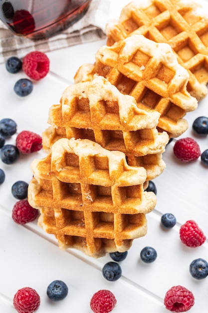 waffles with blueberries and raspberries on white table