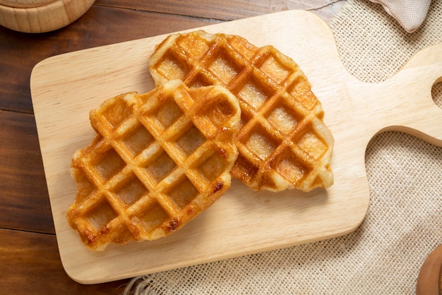 Waffles with butter and honey on a wooden tray ready to serve.