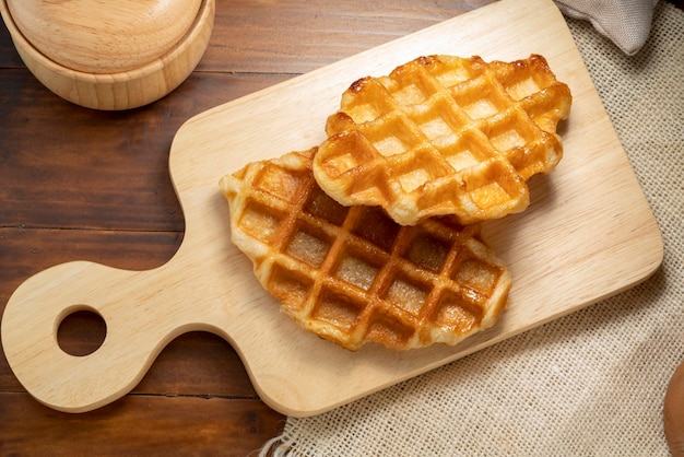 Waffles with butter and honey on a wooden tray ready to serve.