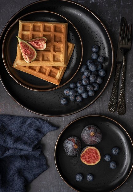 Waffles with fruit on a balck plate