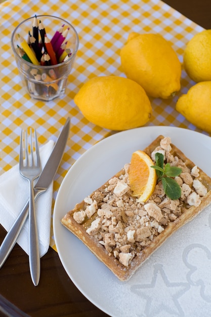 Waffles with meringue, lemon curls and orange slices for breakfast