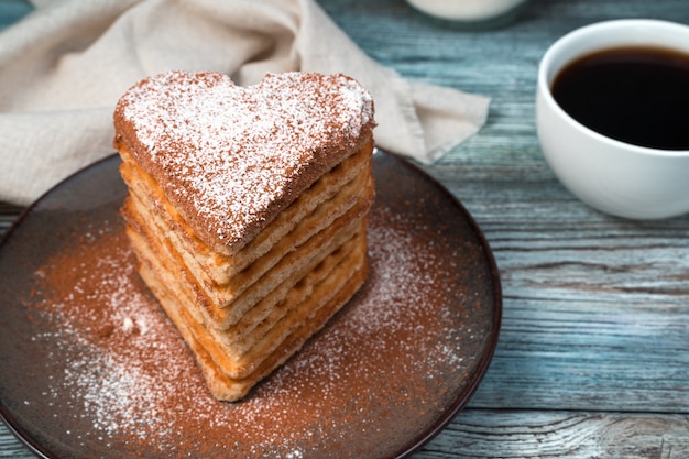 Waffles with powdered sugar and cocoa in the shape of a heart