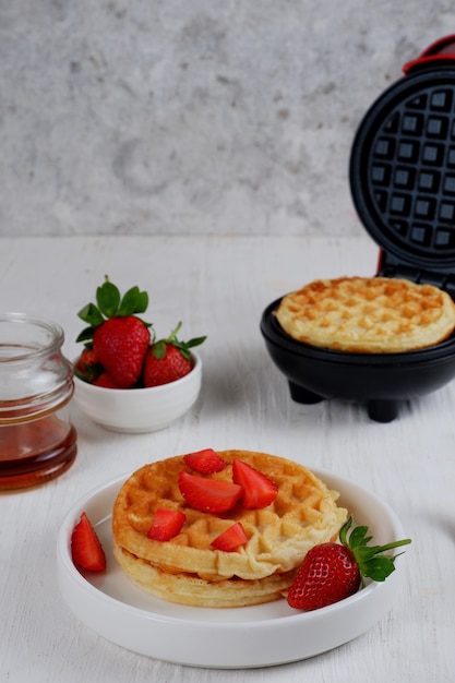 Waffle con fragole su sfondo bianco