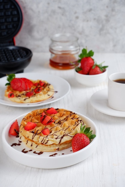 Waffle con fragole su sfondo bianco