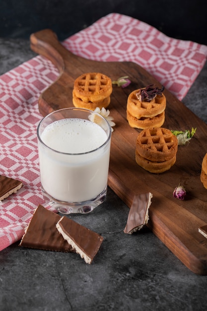 Waffles on a wooden board with a cup of milk