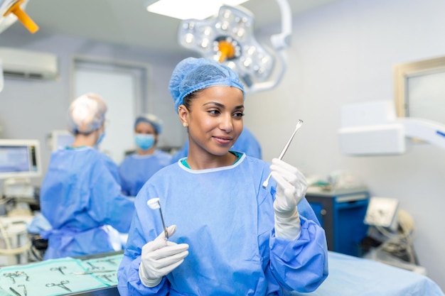 Waist up portrait of African American female medical worker in protective mask preparing for surgery Surgeon and his assistant on blurred background