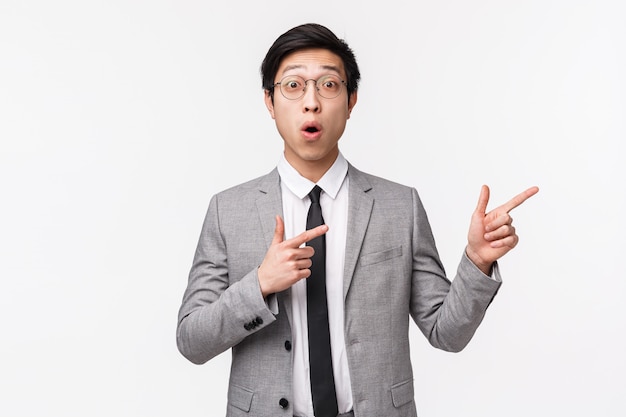 Waist-up portrait of amazed and impressed, enthusiastic asian young man