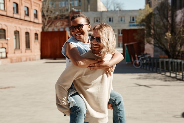 Waist up portrait of carefree young couple having fun in Summer city