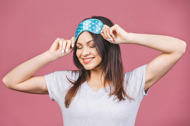 Waist up portrait of cheerful smiling girl in sleeping mask