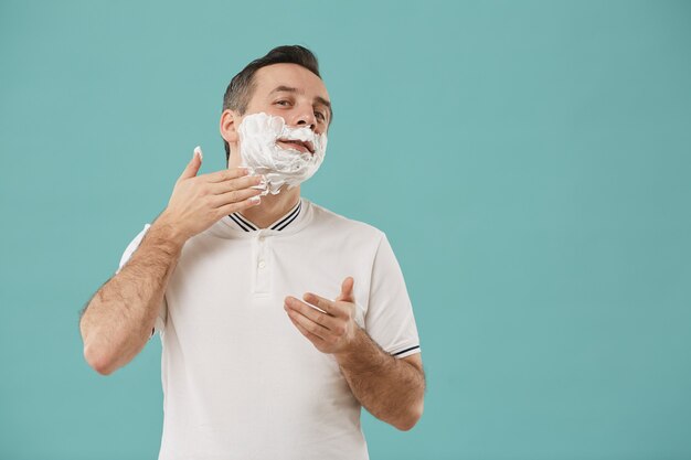 Waist up portrait of modern adult man shaving