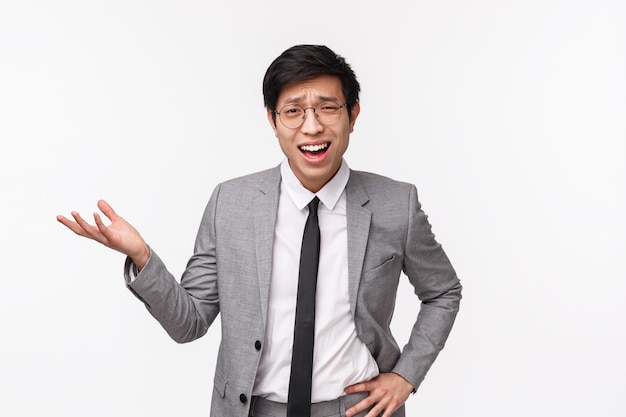 Waist-up portrait of skeptical and frustrated asian young businessman in suit