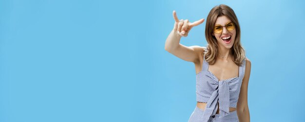 Waist-up shot of confident and daring charming young woman in matching trendy clothes yelling yeah person