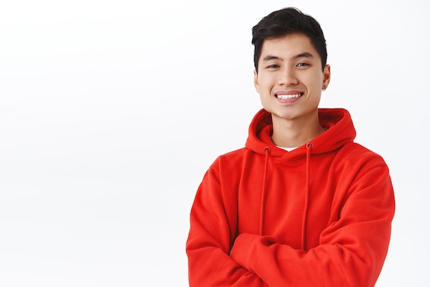 Waistup portrait of professional successful young asian male student applied job got employed starting career in it company look satisfied cross hands over chest confident white background