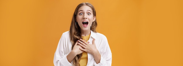 Photo waistup shot of excited and thrilled happy expressive european woman in blouse over tshirt gasping f