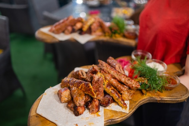 Waiter carrying two plates with meat dish on some festive event, party, wedding reception or catered event.