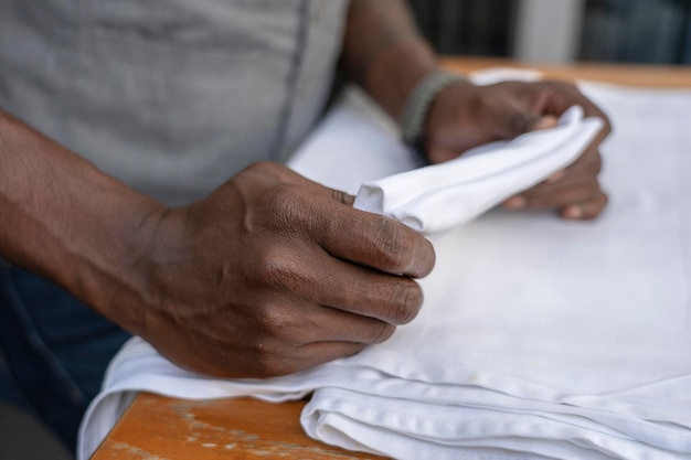 Waiter folds napkins in restaurant Waiters hands with white napkin closeup