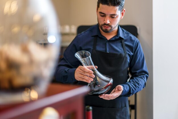 Waiter hold bottle of red wine