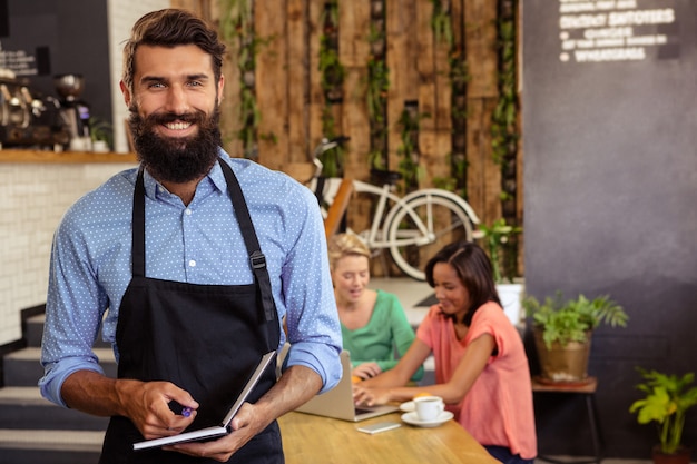 Photo waiter holding a book and pen