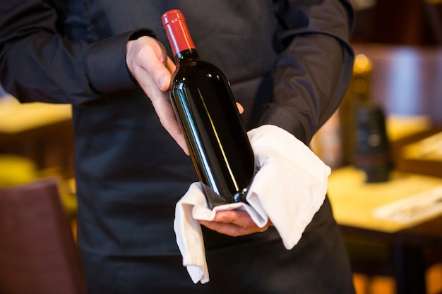 Waiter holding a bottle of red wine