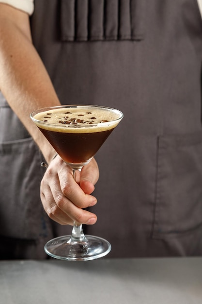 Waiter holding a glass of coffee coctail