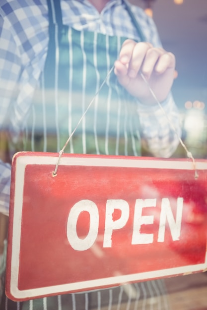 Waiter holding open signboard