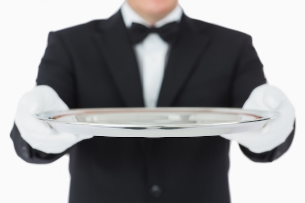 Waiter holding a silver tray with both hands