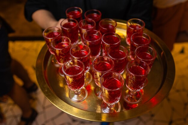 Waiter holding tray with aperol spritz cocktail summer drink