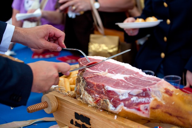 Waiter is slicing ham