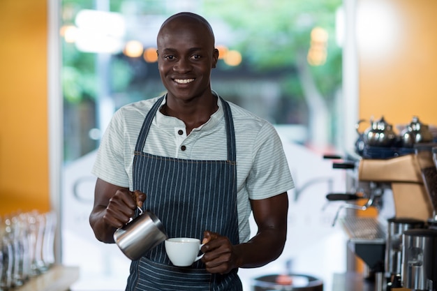 Cameriere che fa tazza di caffè al bancone